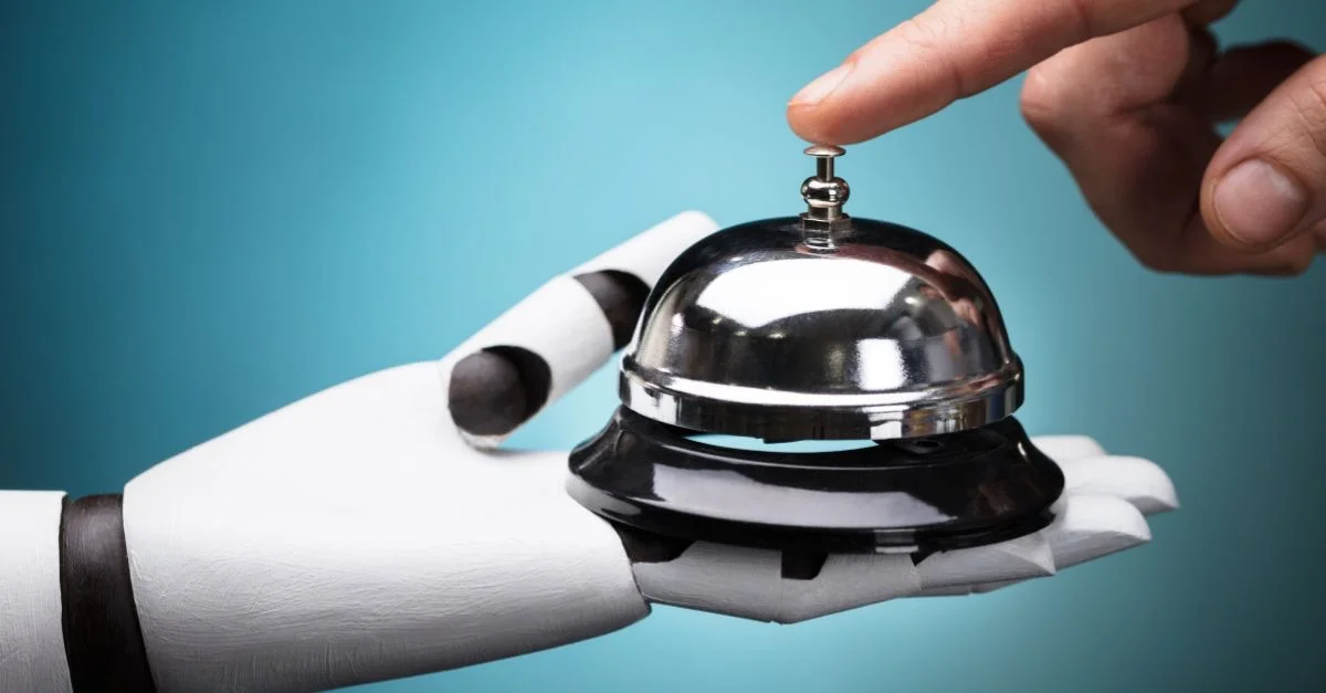 Robot hand holding a service bell, touched by a human finger
