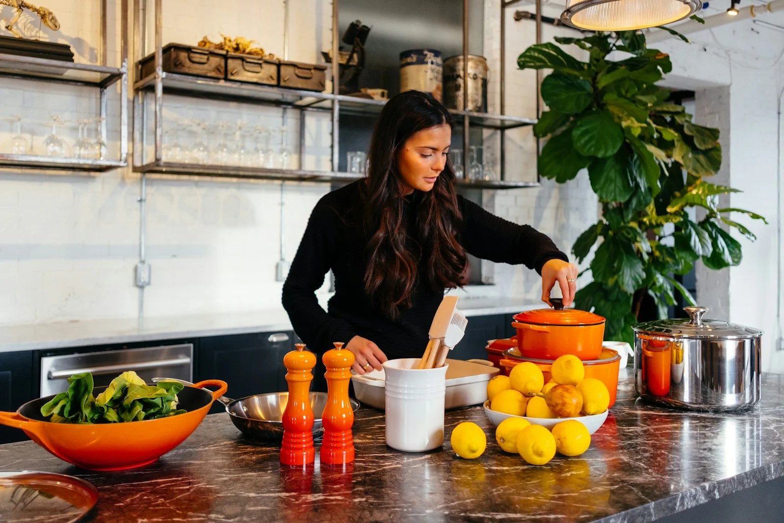 A woman cooking in a bright kitchen, surrounded by pots and lemons