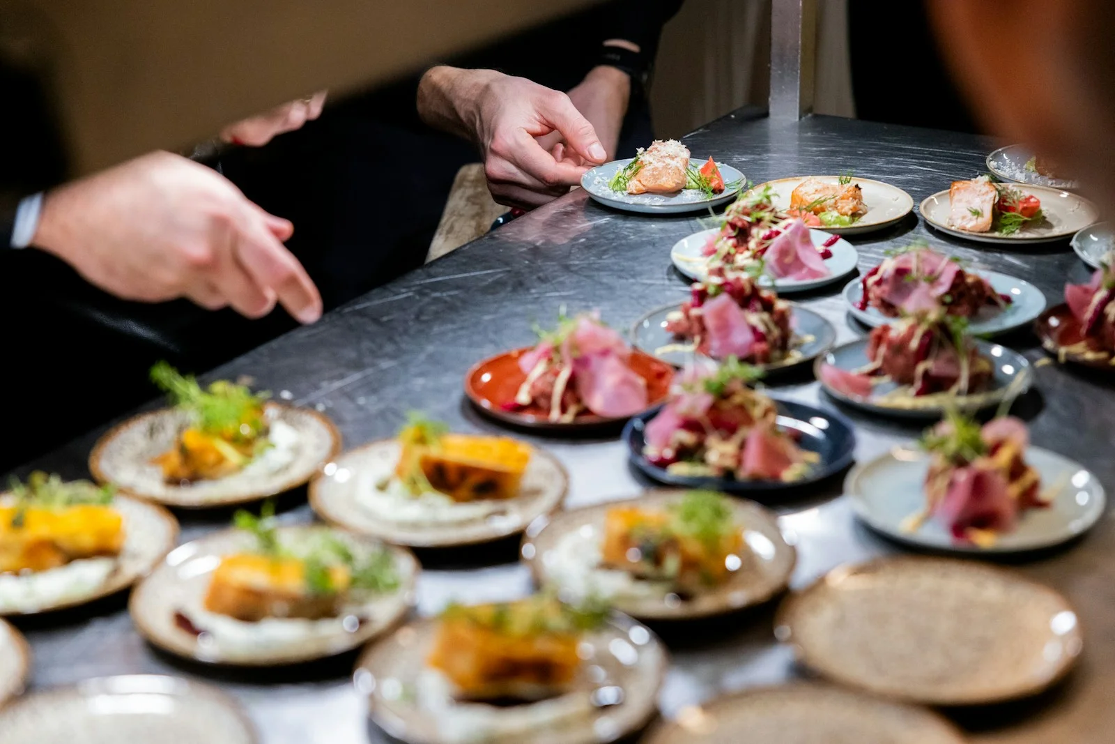 Plates dressed in a row on the pass of a catering kitchen